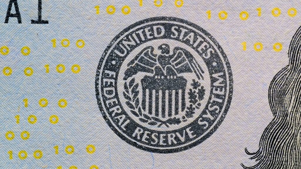 Federal Reserve System seal on a U.S. $100 bill.