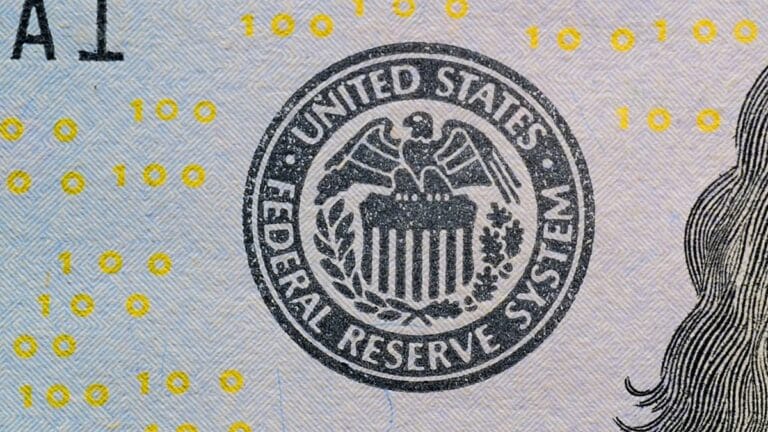 Federal Reserve System seal on a U.S. $100 bill.